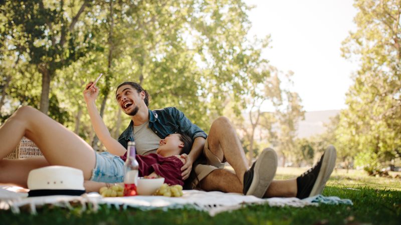 Smiling couple taking selfie on picnic