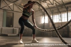Athlete working out with battle ropes at cross gym 0yXxWL