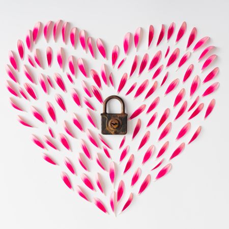 Heart made of pink flower petals with lock