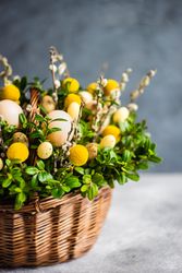 Side view of Easter card concept with fresh basket of greenery with decorative eggs