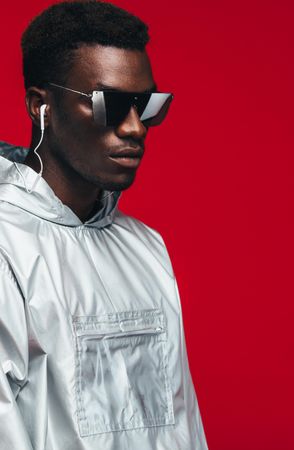 Trendy fashion portrait of man wearing silver outfit and stylish sunglasses