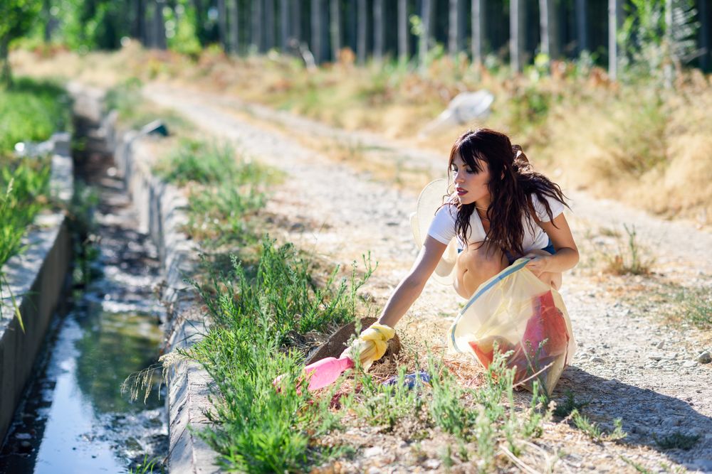 Female cleaning up litter on footpath