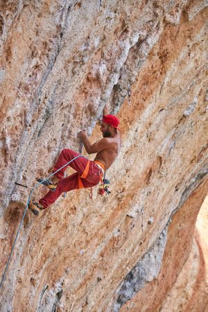 Climber ascending rocky mountain slope