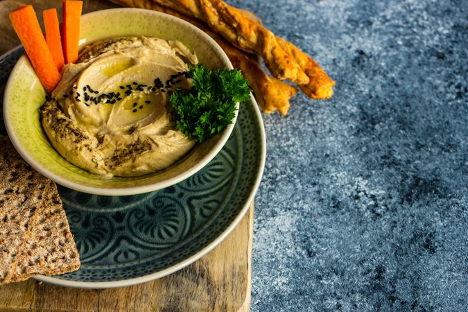 Traditional hummus dish in bowl on grey counter with space for text