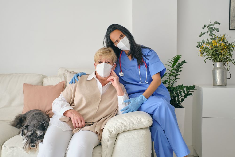 Physician embracing patient on sofa with dog after examination