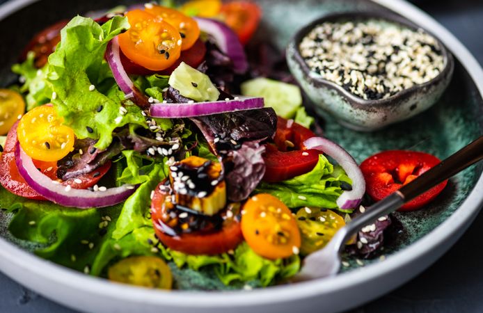 Close up of organic vegetable salad with side of sesame seeds