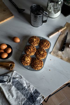 Homemade muffins and cooking ingredients on table