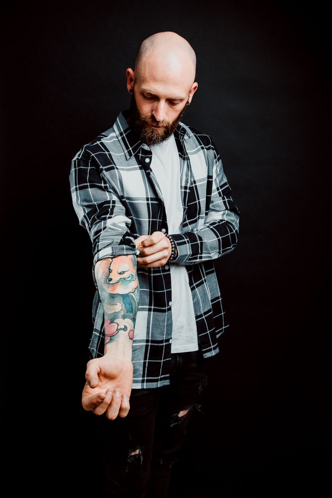 Young bald guy showing tattoos