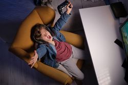 Expressive boy celebrating victory while playing videogame