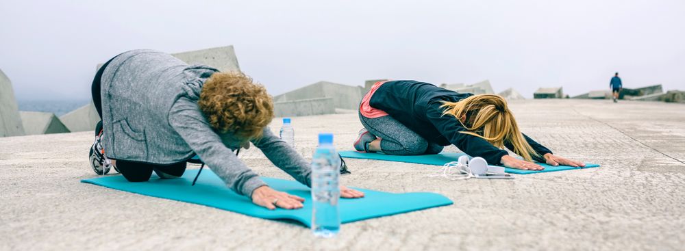 Unrecognizable young and Mature woman stretching back outdoors