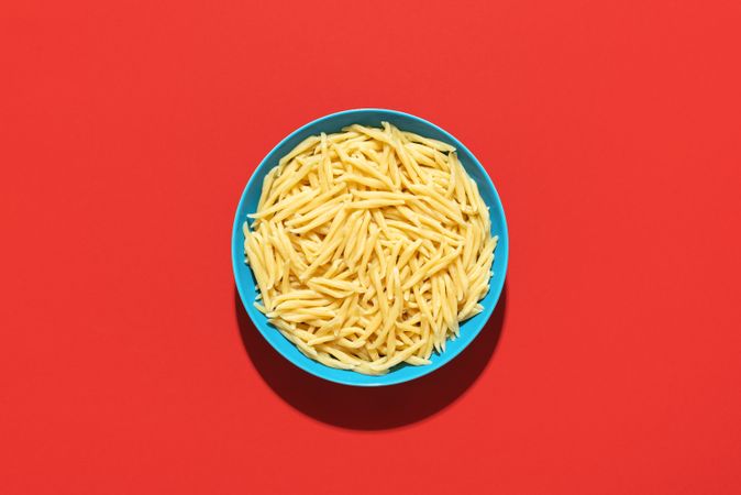 Trofie pasta bowl top view on a red background