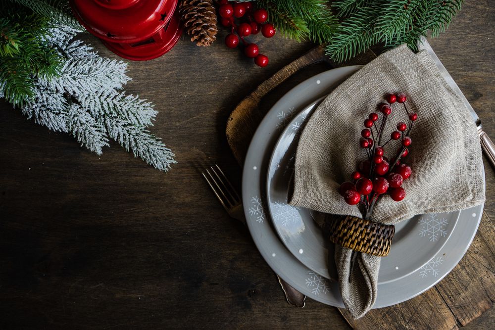 Top view of holly berries on xmas table setting with copy space
