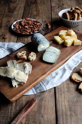 Croutons and nuts near board with cheese