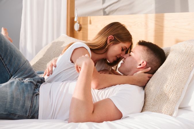 Passionate couple kissing on bed of bubble room