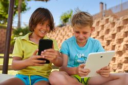 Boys using tablet in garden