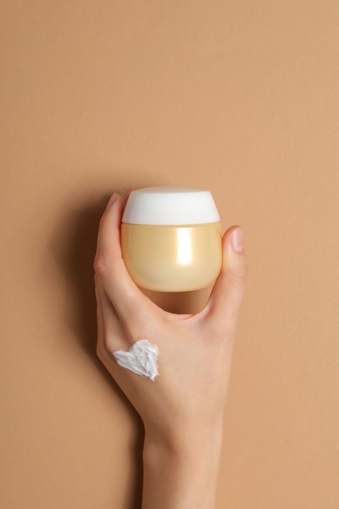 A jar of hand cream on a light, beige background.