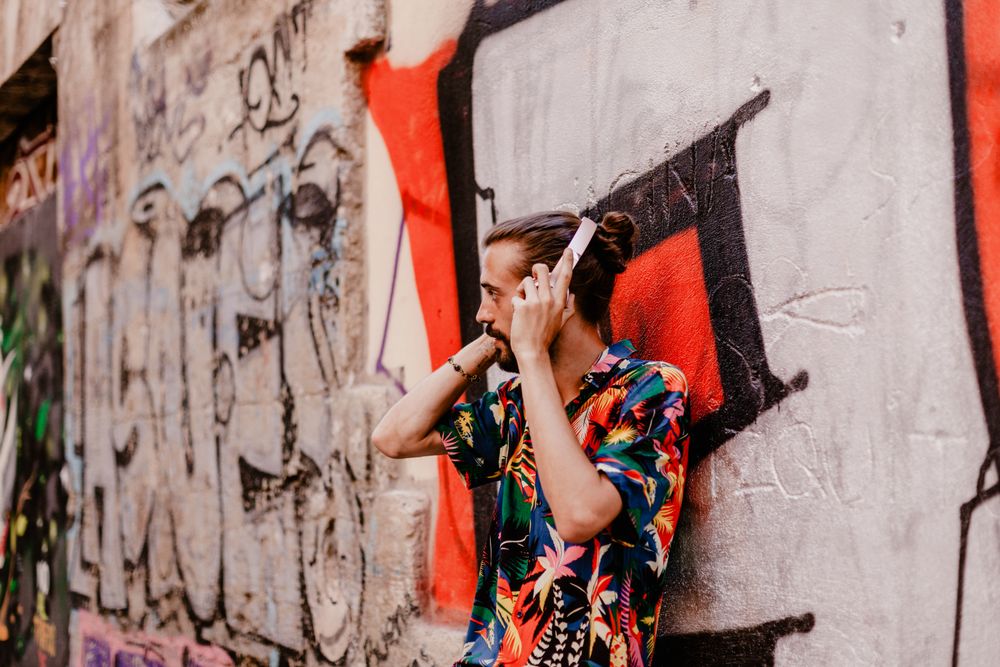 Smiling man listening to music and using smartphone