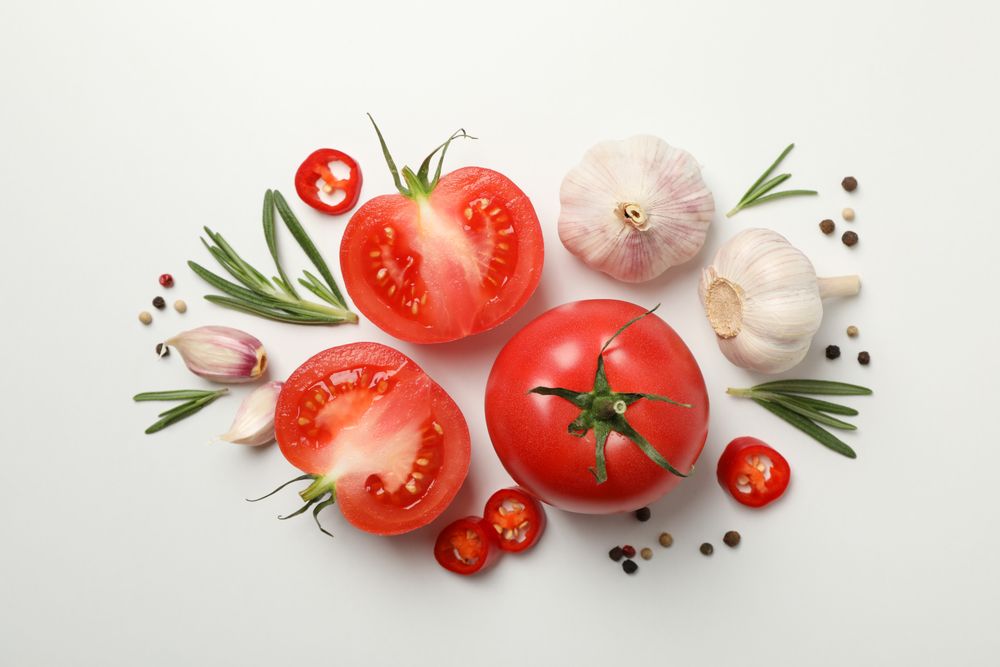 Tomatoes and ingredients on neutral background, top view
