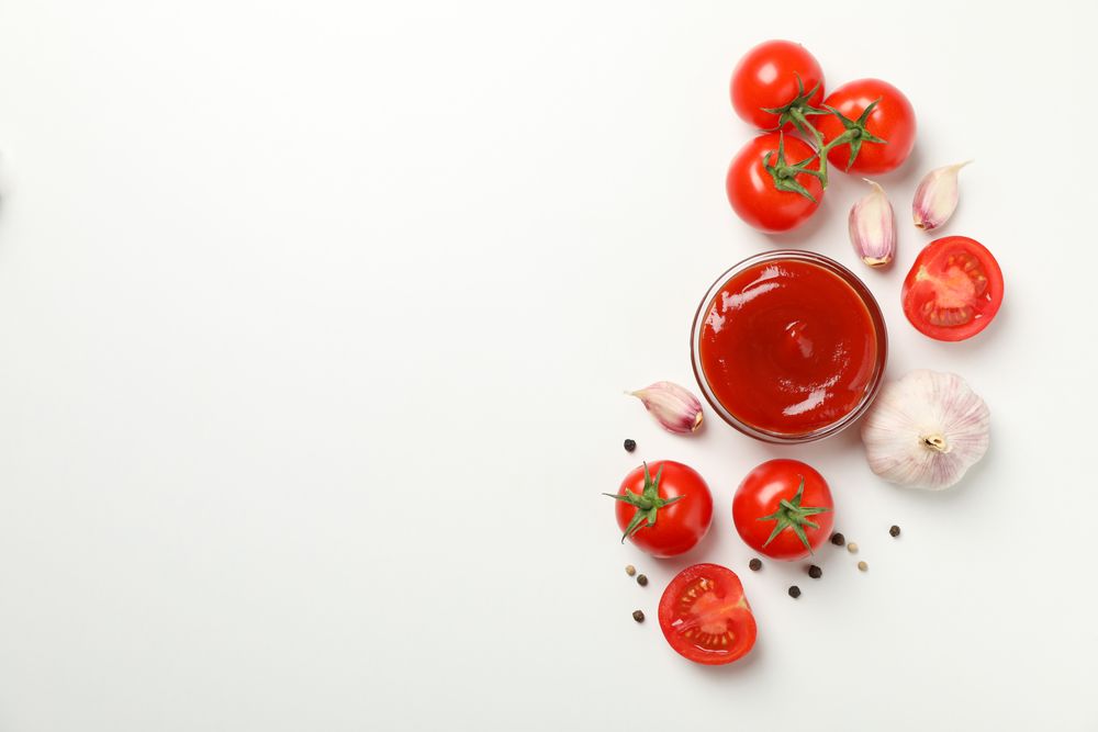 Tomatoes, sauce and ingredients on neutral background, top view