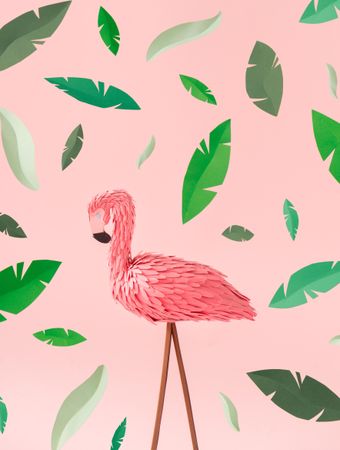 Pink flamingos on pink background, with green leaves