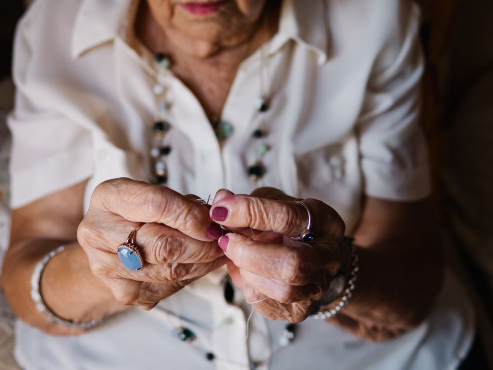 Mature woman with threads sitting at home