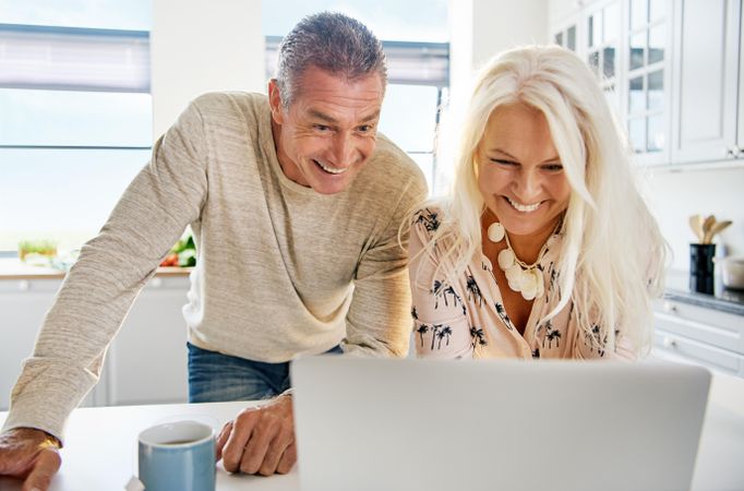 Happy older couple smiling at laptop screen