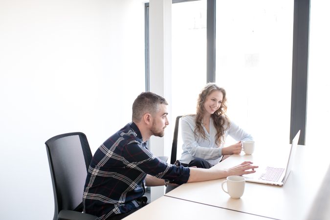Cheerful colleagues working on laptop together