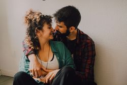 Happy couple embracing on wall at home