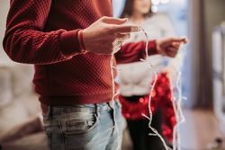 Young couple arranging Christmas tree at home