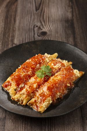 Pancakes stuffed with minced meat and topped with tomato sauce and grated cheese.