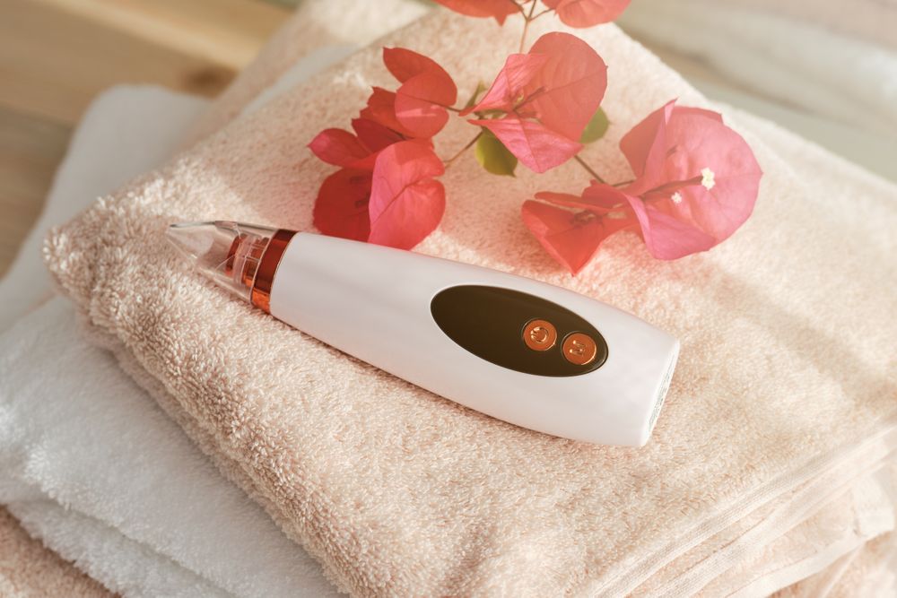 Blackhead remover near flowers on towels