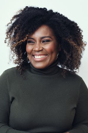 Portrait of a Black woman smiling looking away from the camera