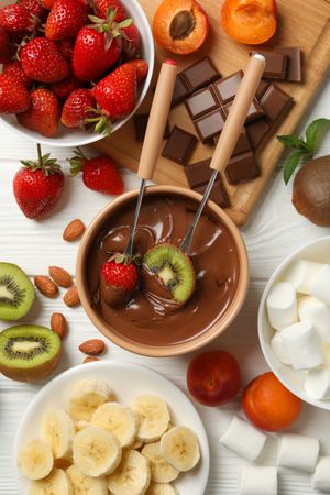 Composition with ingredients for chocolate fondue on wooden background. Cooking fondue