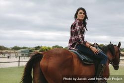 Beautiful young woman riding horse inside corral ranch 5ldja5