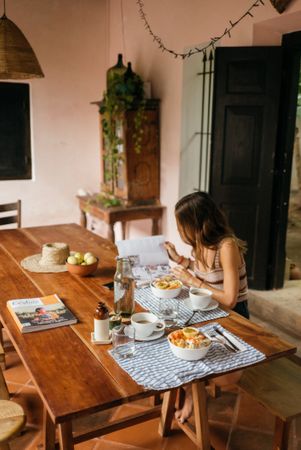 Woman reading magazine at breakfast table