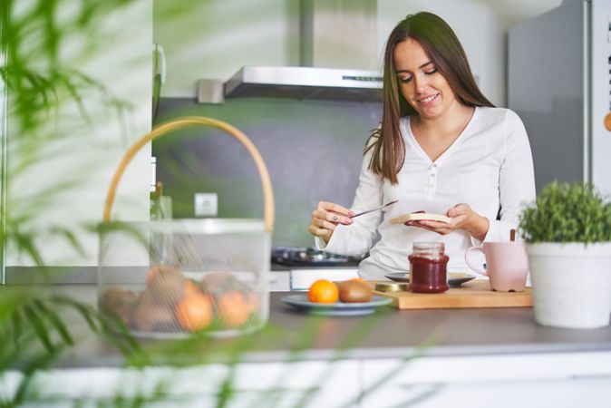 Smiling woman making sandwiches in kitchen