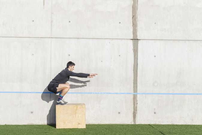 Man training on sports ground near wall