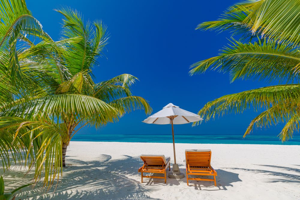 Reclining lounge chairs on a tropical beach in the Maldives
