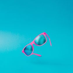 Pink sunglasses on blue background