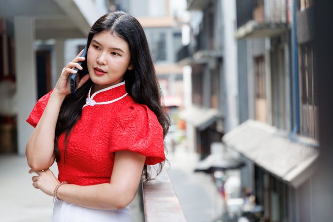 Asian person talking on mobile phone standing in the city