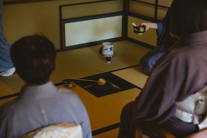 Group of people in kimonos attending tea ceremony