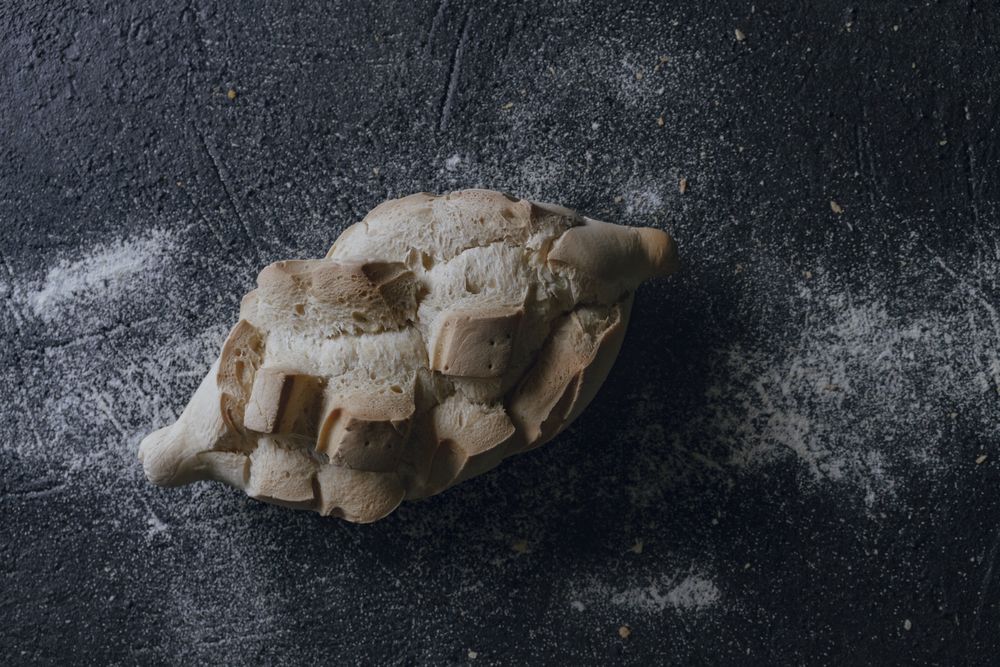 Loaf of bread with incisions on grey texture background