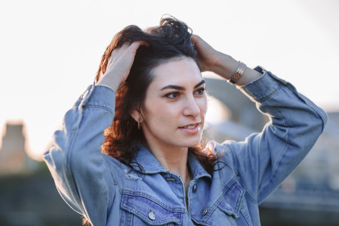 Woman with hands in hair at sunset