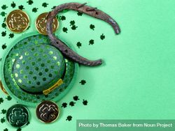 St Patrick’s Day lucky horseshoe with coins and hat on light green background 4jKJrb