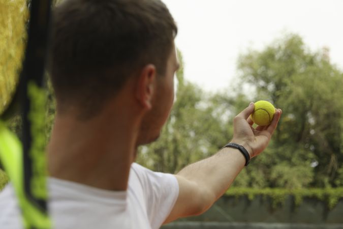 Young man in white t-shirt serve the tennis ball