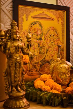 Hindu deity golden figurines surrounded by marigold flowers