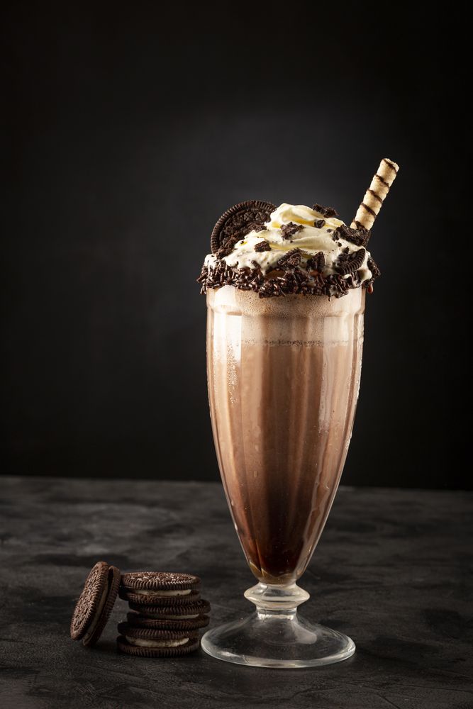 Chocolate milkshake with pieces of chocolate chip cookies.