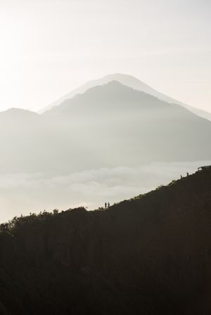 Silhouette of mountain under cloudy sky