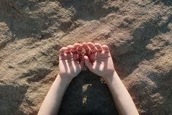 Close up of hands resting on the ground