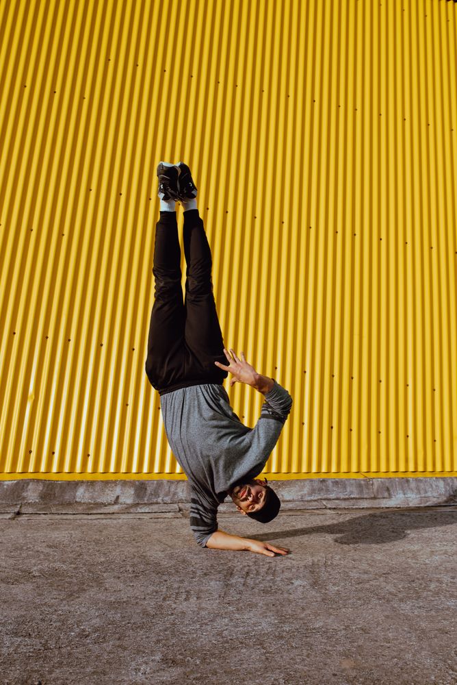 Man performing handstand near wall